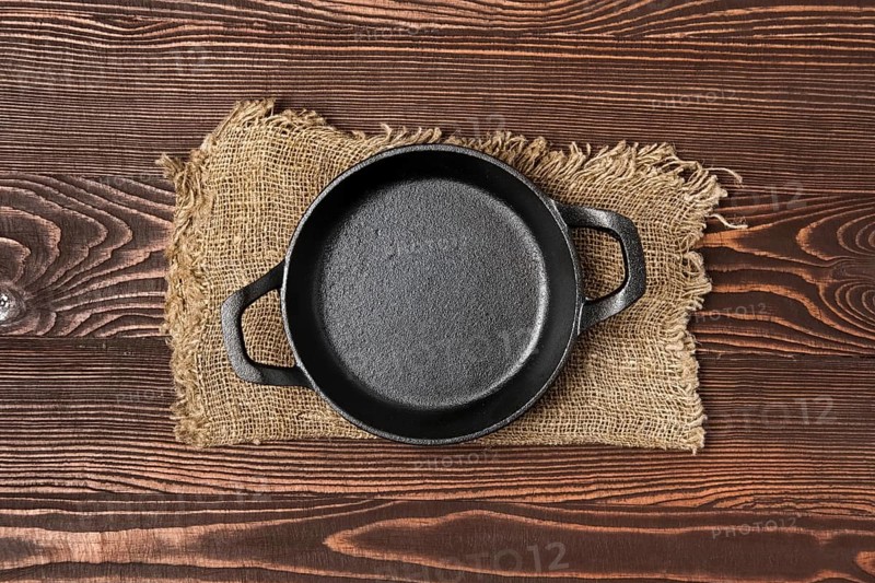 Empty mini cast-iron skillets on wooden table