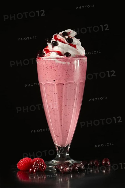 Glass of fruit cocktail on black background
