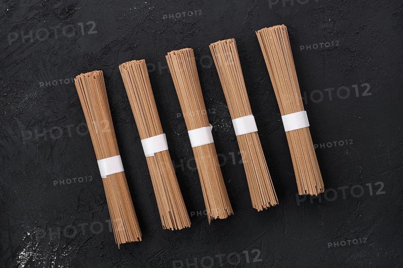 Dry soba buckwheat noodles on black concrete background