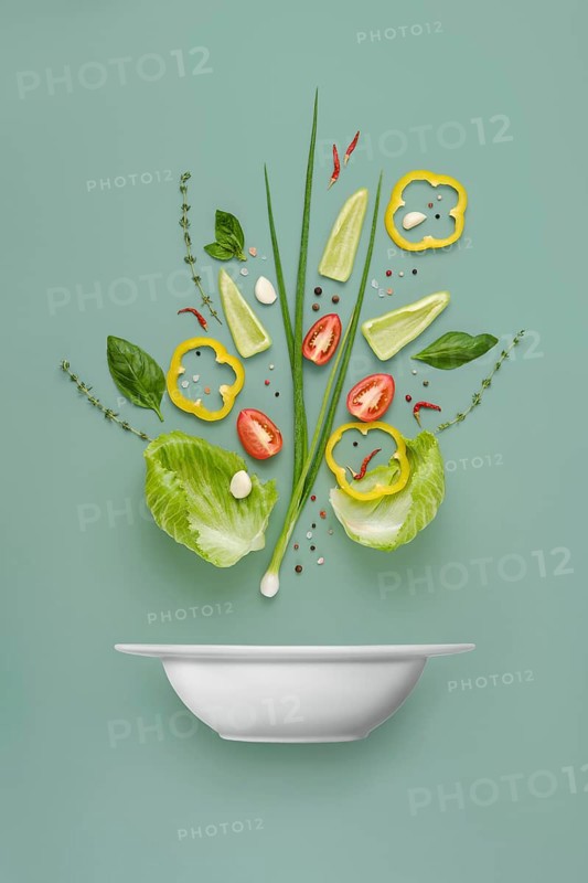 Recipe of vegetable salad organized into component parts over solid background