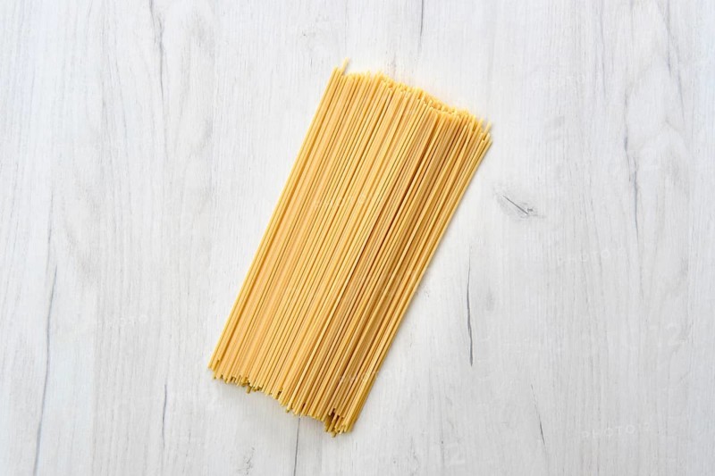Overhead view of raw spaghetti on wooden table