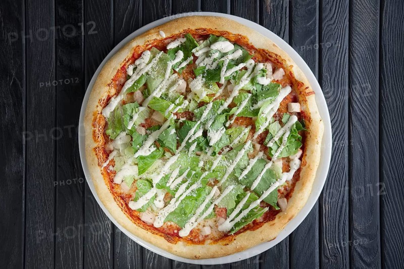 Top view of pizza wth pickled cucumber and salad