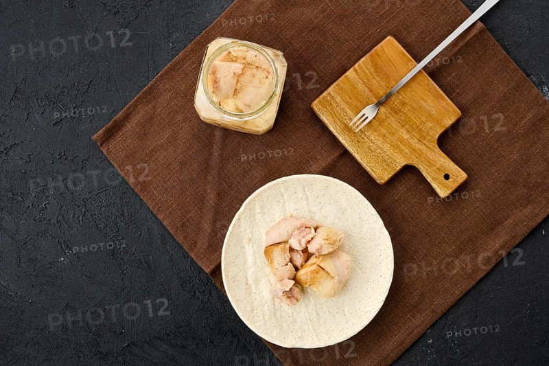 Top view of canned cod liver in glass pot on the table