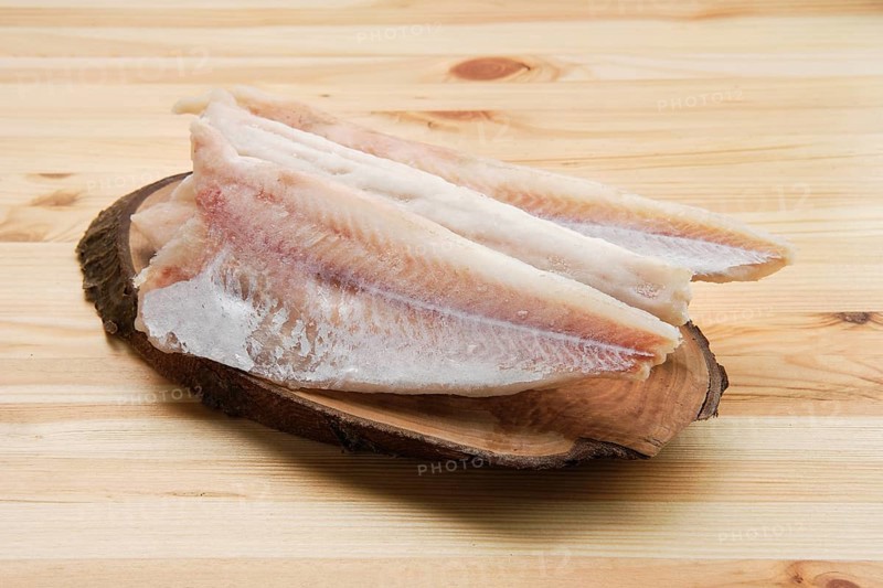 Frozen fillet of pangasius on wooden table