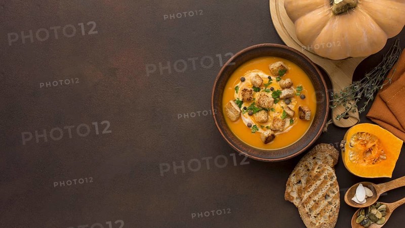 Flat lay winter squash soup with copy space croutons bowl