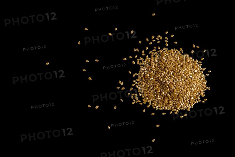 Top view of gold plated sesame seeds on black background
