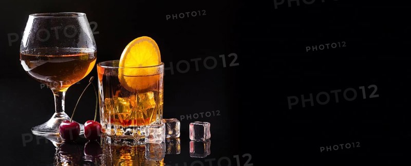 Front view whiskey with orange cognac glass with copy space