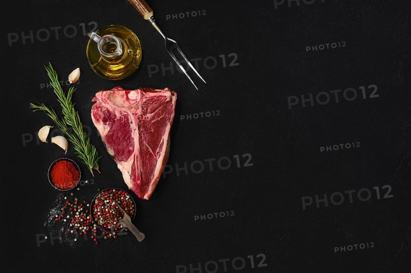 Overhead composition with raw porterhouse steak with ingredients for cooking with copy space