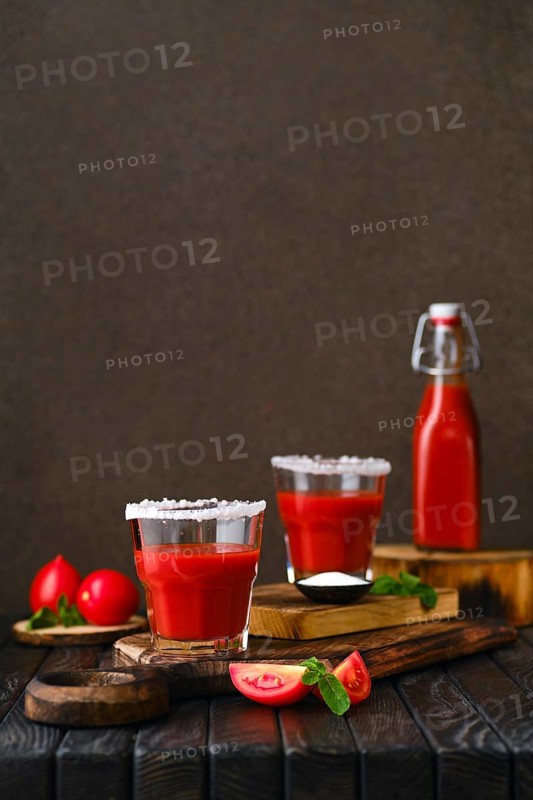Composition with salty tomato juice on dark wooten table