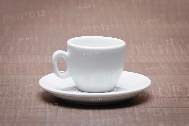 Clean and empty ceramic cup for espresso with saucer on wooden table