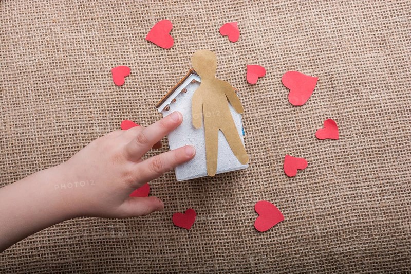 Heart shaped icons and paper house on canvas