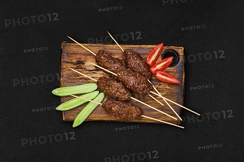 Lamb kebab on skewer on wooden board