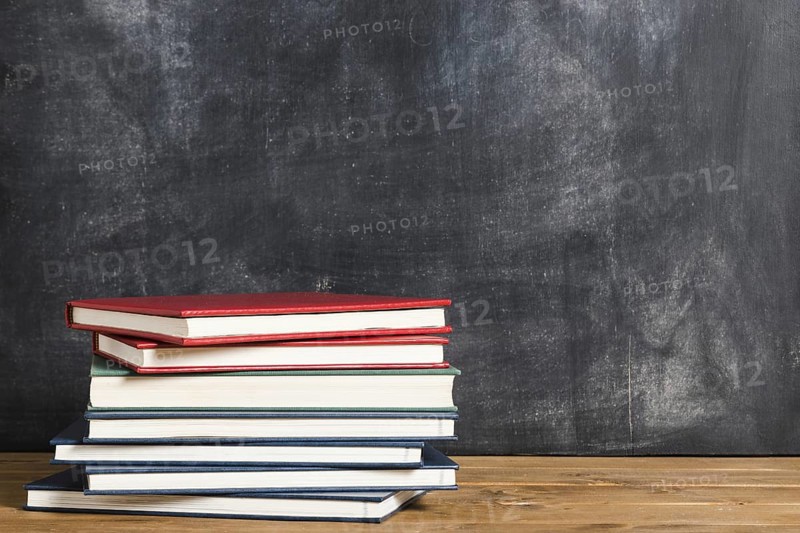 Colorful books front blackboard