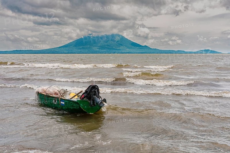A wooden fishing boat on the shore of a lake