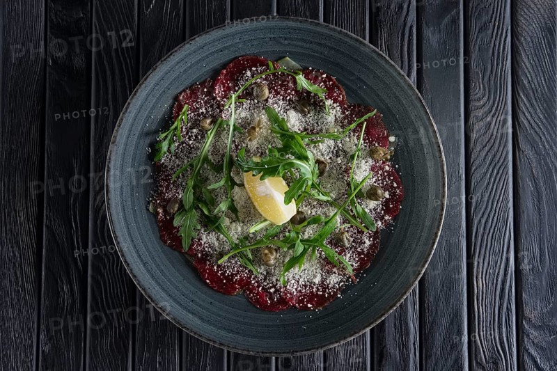 Top view of beef carpaccio with grated cheese