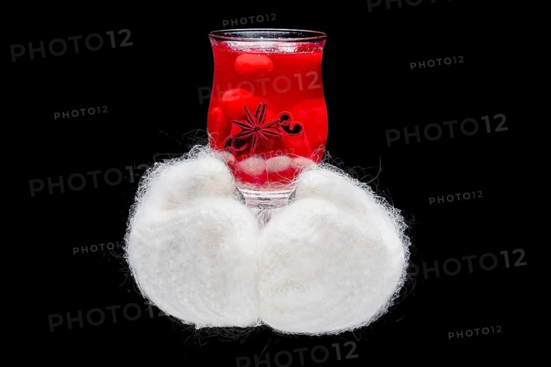 Hands in warm gloves holding hot cup with herbal tea