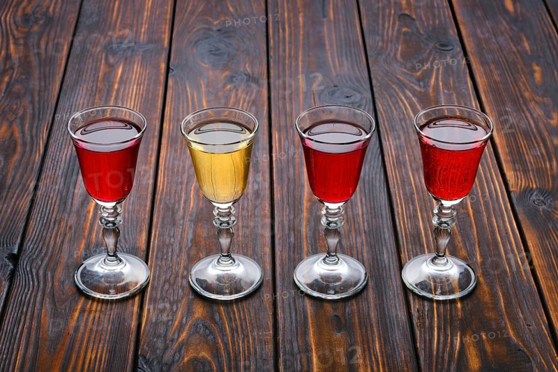 Vodka infused with berries on wooden background
