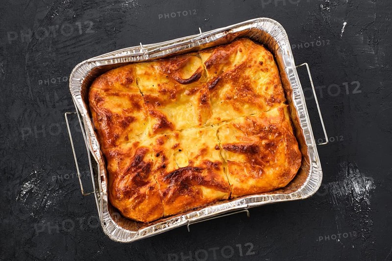 Georgian pie with cheese achma on black wooden background