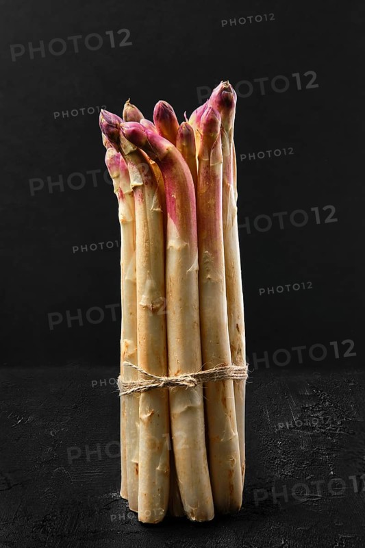 Bunch of asparagus stalks on black background