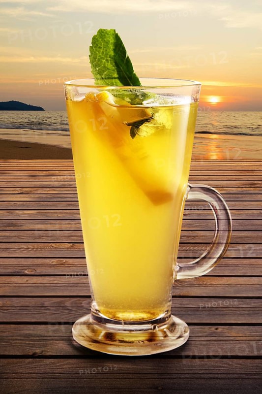 Cold citrus tea on the table with sunset view on background
