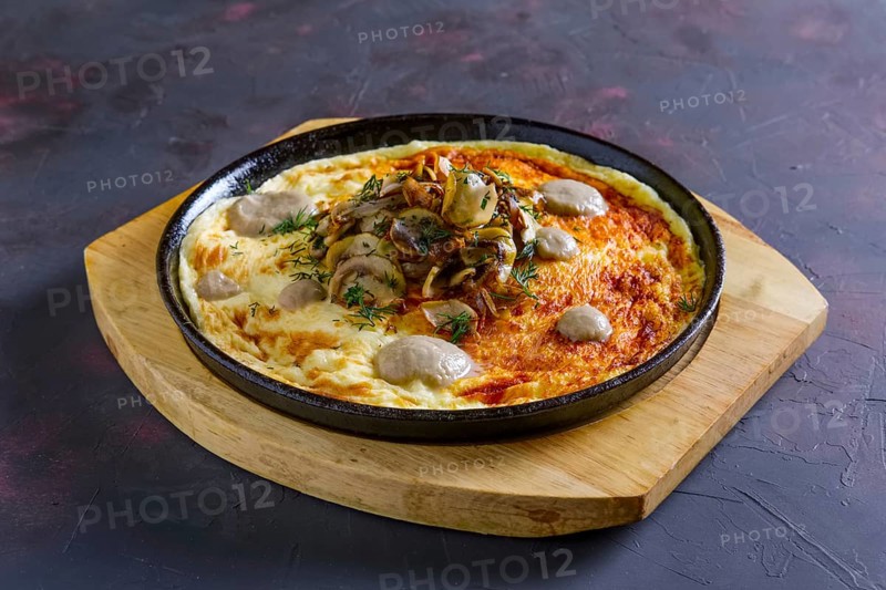 Vegetarian omelette with mushrooms in cast iron pan