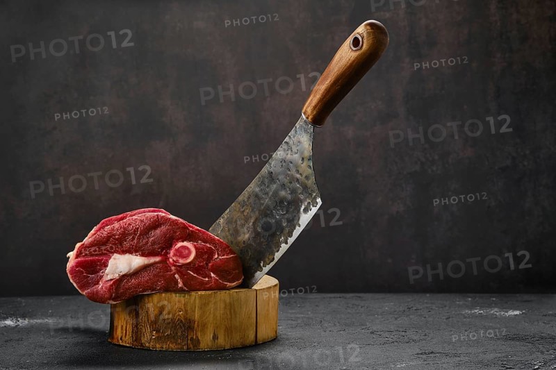 Raw fresh lamb leg and butcher cleaver