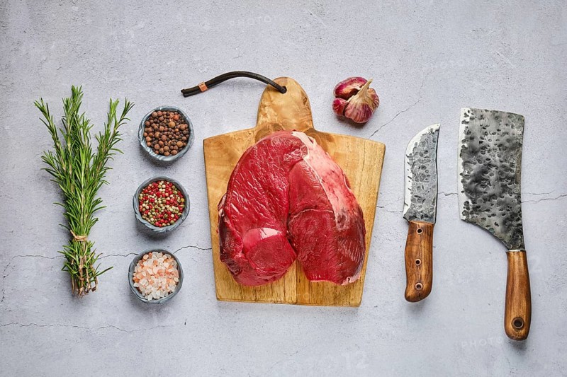 Overhead view of raw fresh deer boneless ham with spice and herb over concrete background