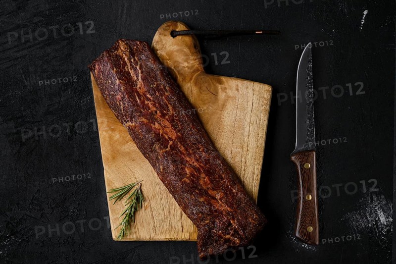 Top view of smoked beef striploin meat on cutting board