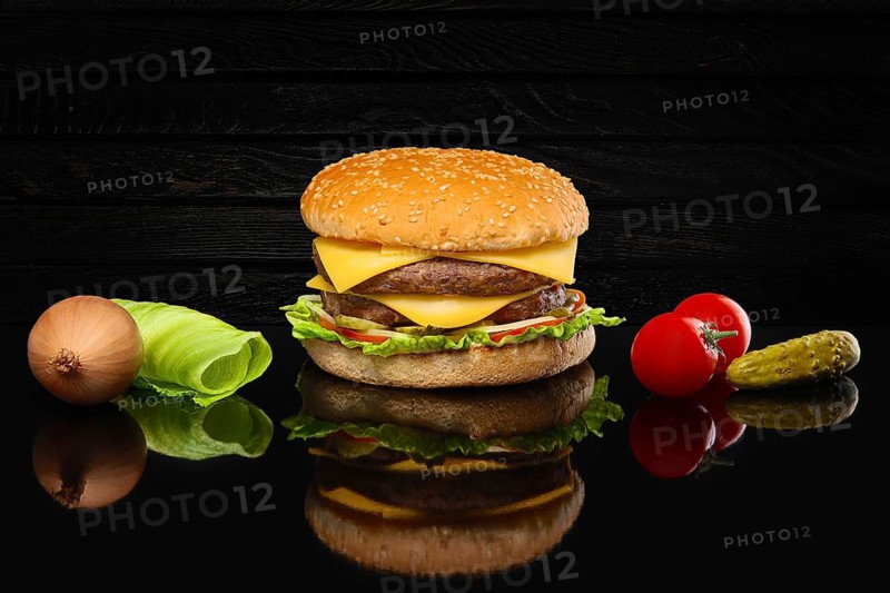 Double hamburger with some ingredients with reflection on glass