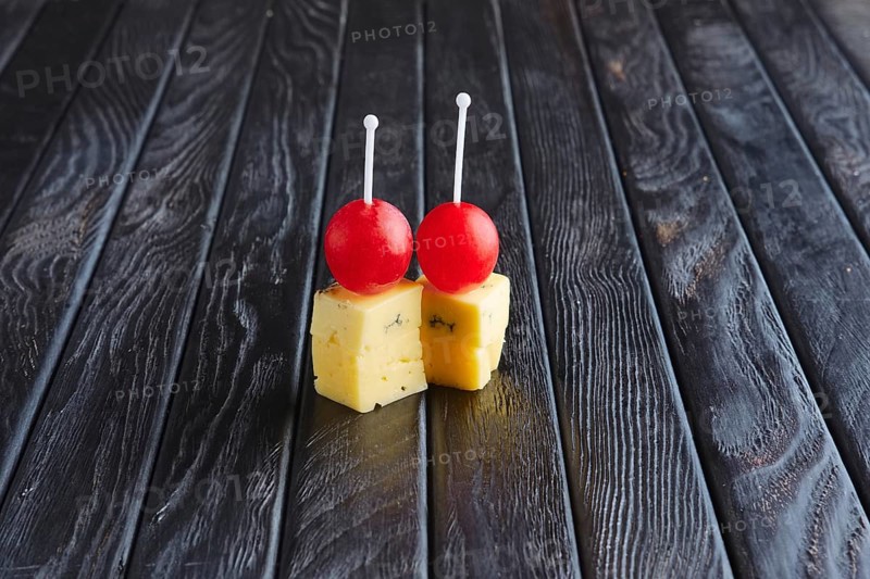 Appetizer for reception. Two kinds of cheese and grape on skewer