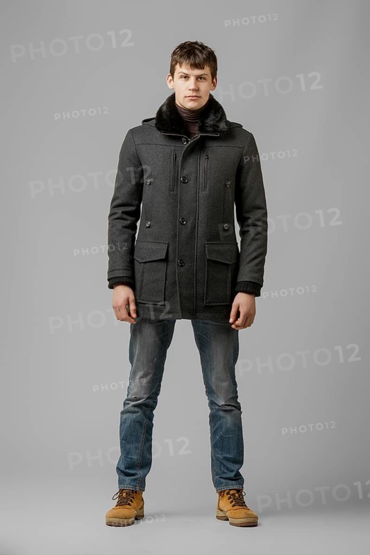 Full length portrait of handsome man in warm winter coat posing in studio
