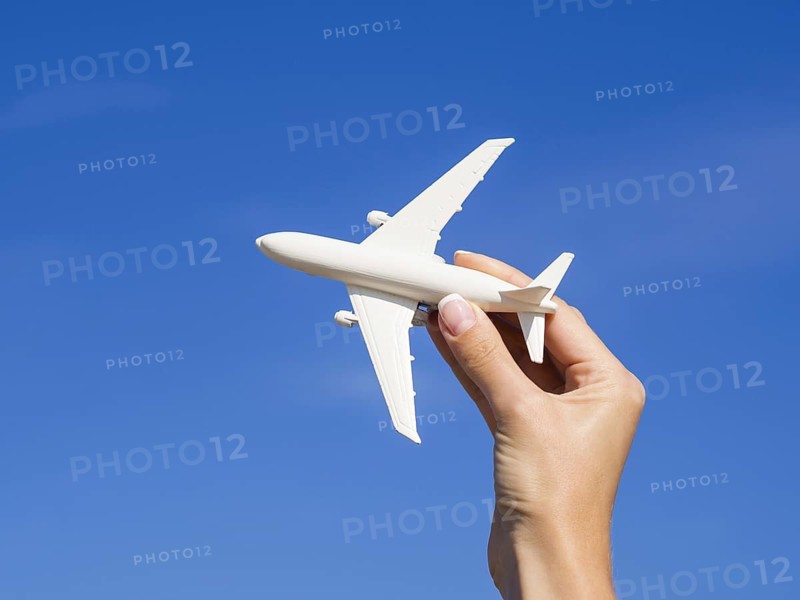 Hand holding plane sky