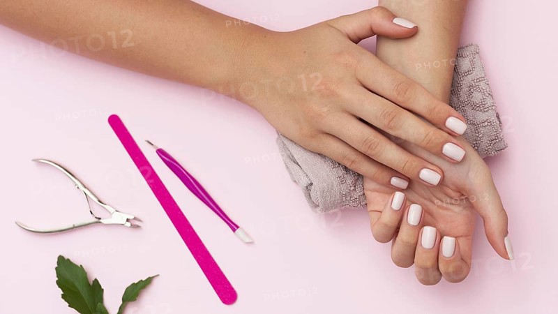 Hands with manicure done and nail care tools