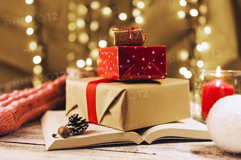 Present boxes book near burning candle