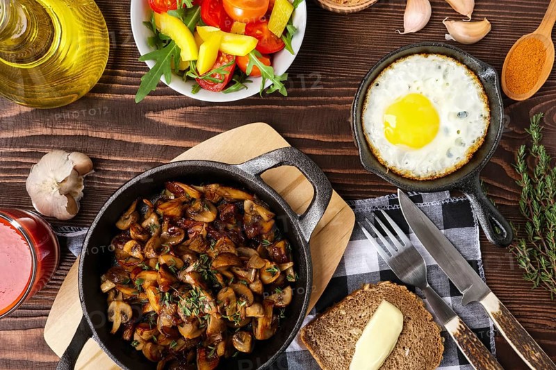 Fried mushrooms and egg in cas-iron skillet. Ingredients for rustic simple food
