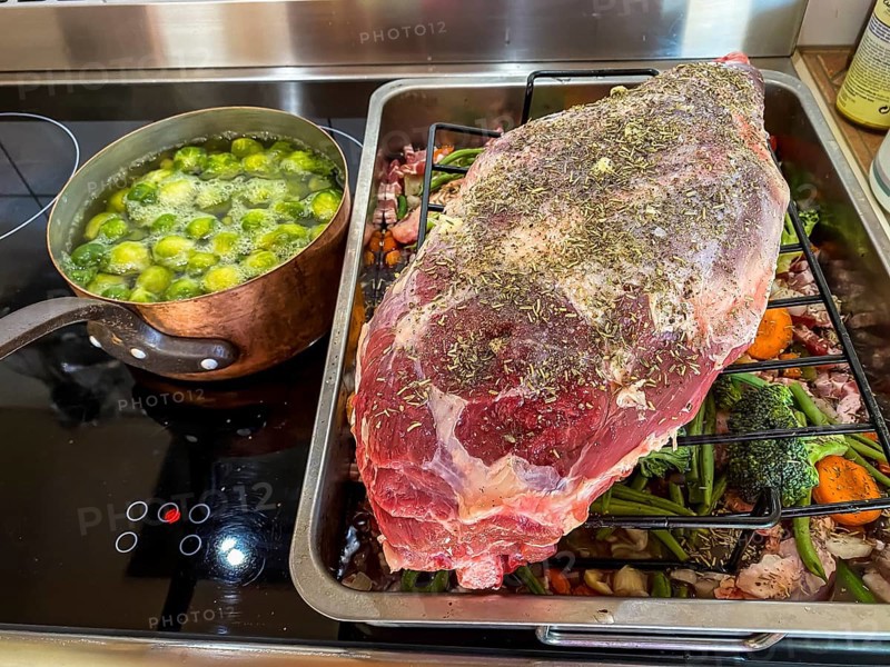 Raw leg of lamb in a roaster with vegetables and spices. Hesse