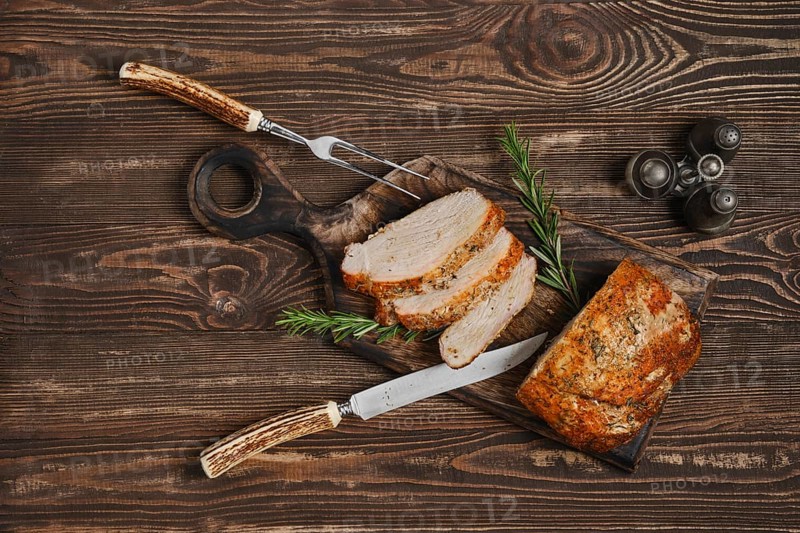 Top view of pork collar joint baked in oven on wooden cutting board