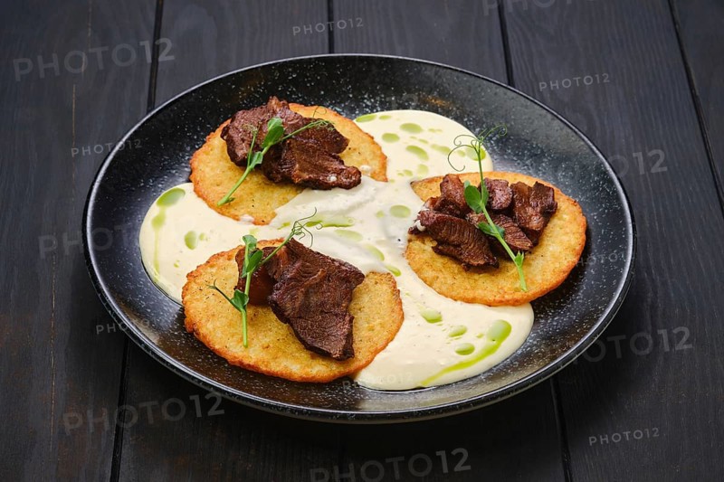 Potato fritters with with fried beef slices