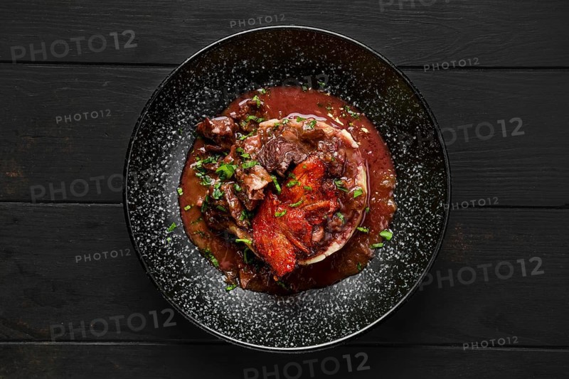 Top view of beef goulash with bacon chips