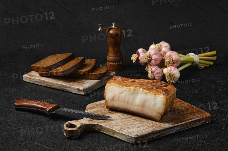 Smoked fat with brown bread on wooden cutting board