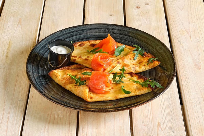 Thin pancakes with salmon and sour cream