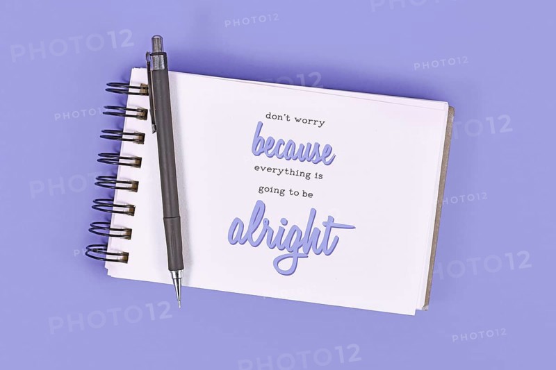 Text 'Don't worry because everything will be alright' in notebook on violet background