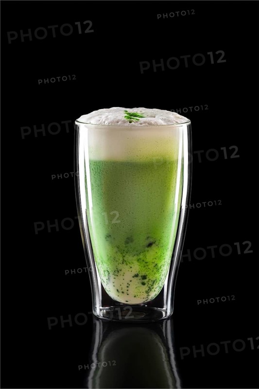 Cup of green tea matcha latte isolated on black background