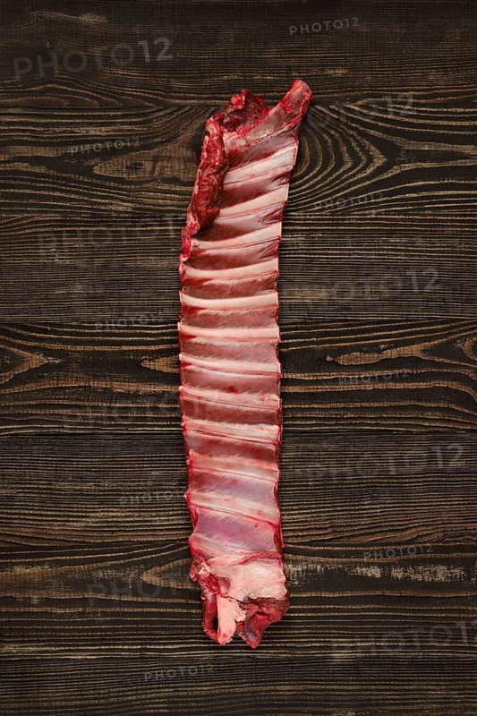 Overhead view of raw deer ribs over wooden background