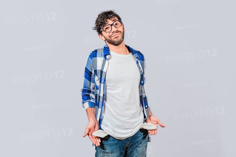 Sad man with no money showing his empty pockets