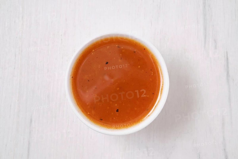 Overhead view of small bowl with spicy orange sauce for poultry