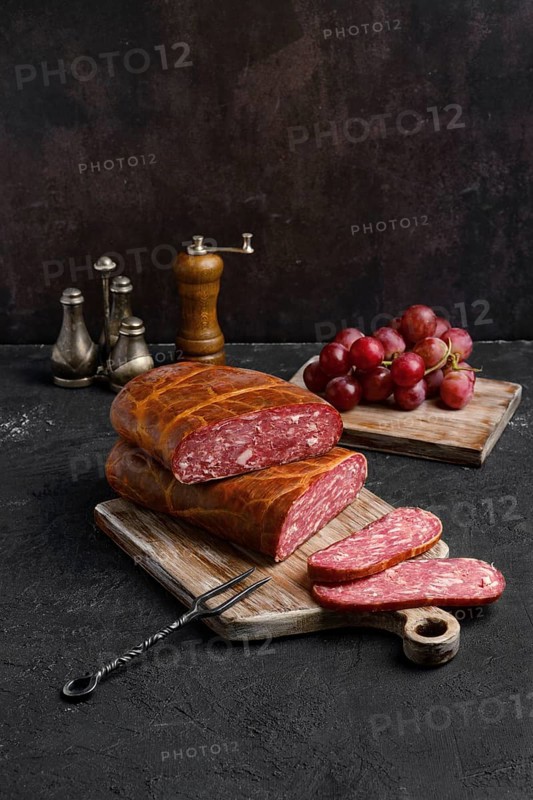 Homemade smoked beef sausage in organic casing on wooden cutting board