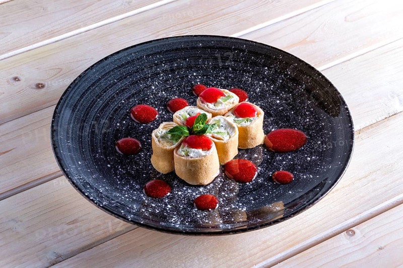 Pancakes stuffed with curd and kiwi decorated with strawberry jam