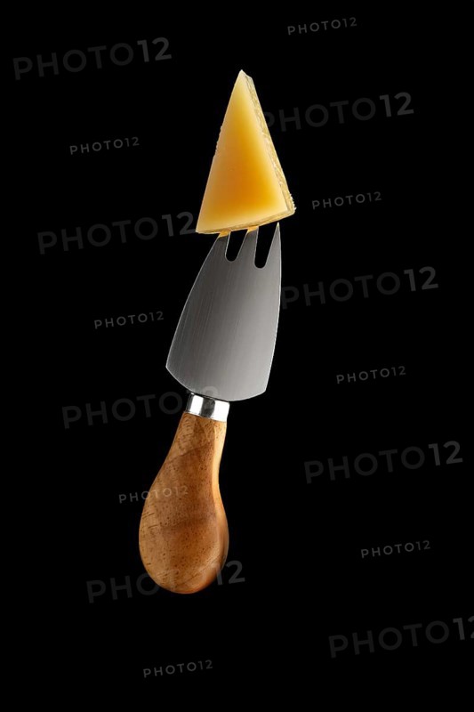 Cheese fork with piece of parmesan on it isolated on black background