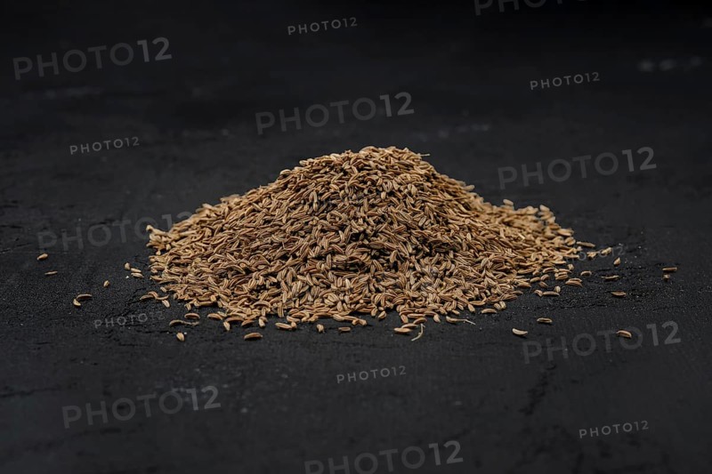 Pile of caraway scattered on dark background